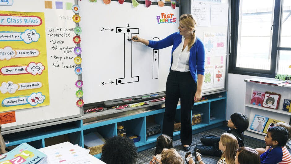 Teacher using teaching phonics on a smartboard 
