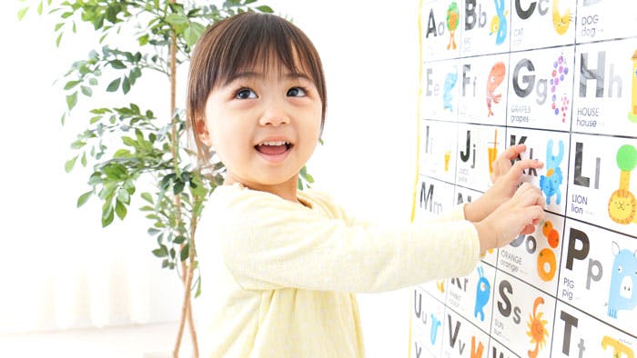Kindergarten child learning letters and their sounds.