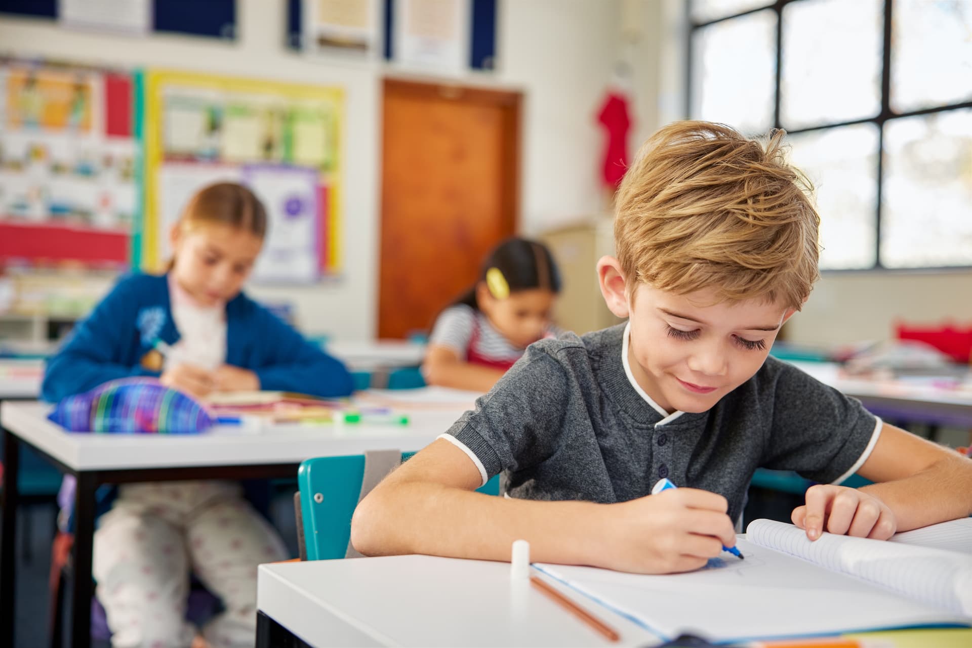 Student sitting at his desk in the classroom (no uniform)
