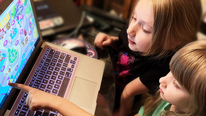Two school girls learning on a laptop with the Reading Eggs program