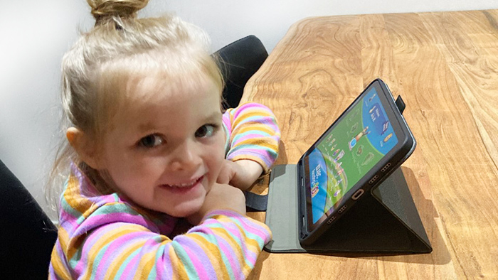 Three-year-old girl does Reading Eggs activity on iPad.
