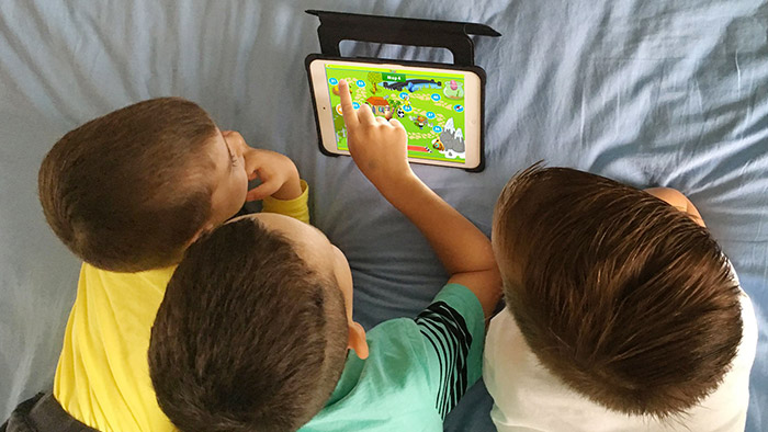 Three children using Reading Eggs on a tablet device